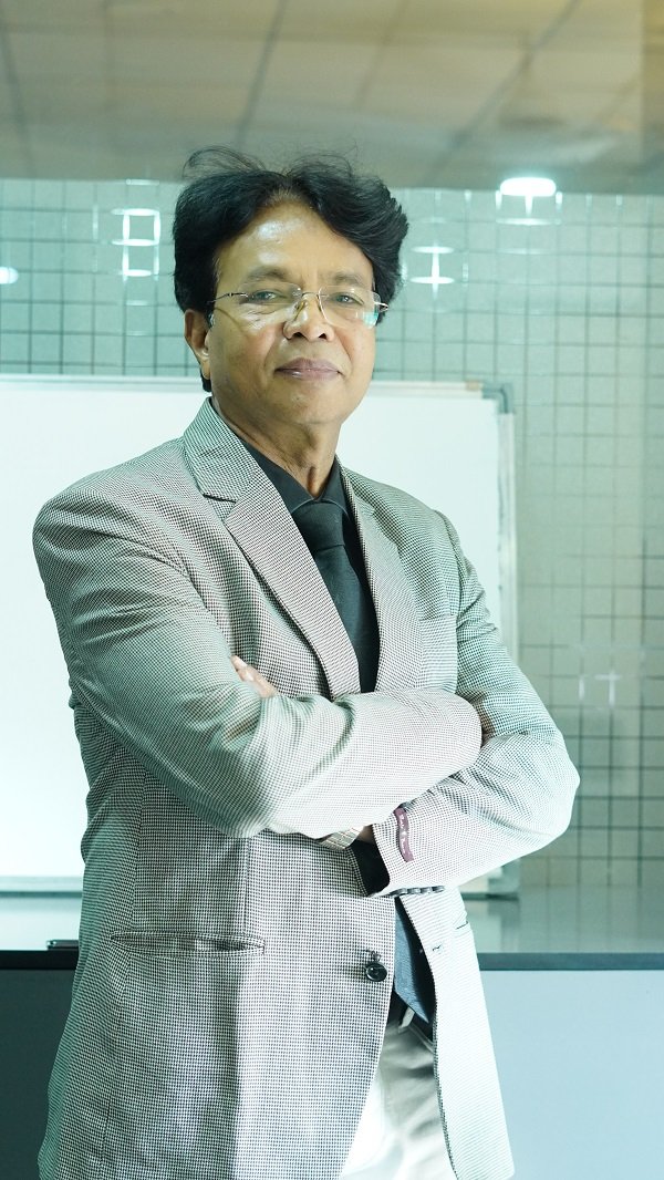 Dr. K. L. Prajapati pictured in a formal setting with a confident, professional posture.